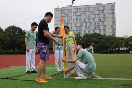 图:董佳乐以及其他场馆志愿者进行赛场维护